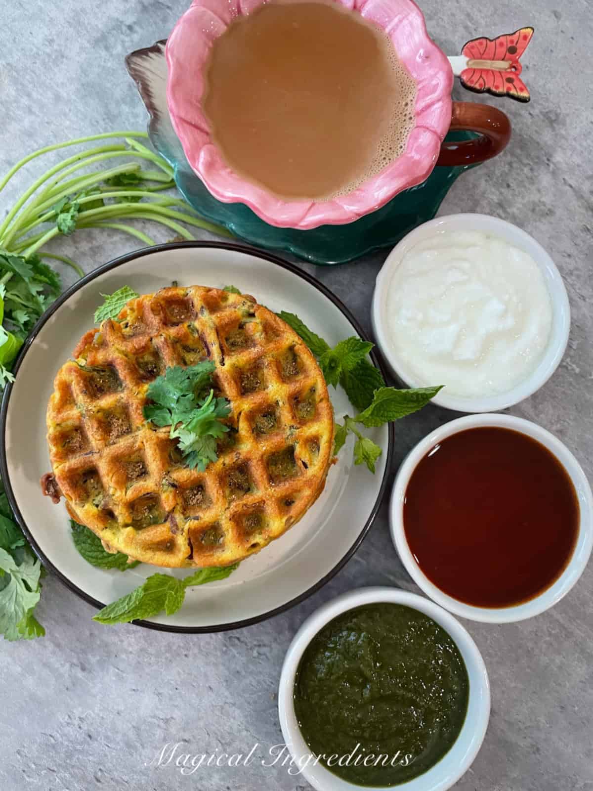 waffles served with ketchup, chutney, yogurt, and ginger chai