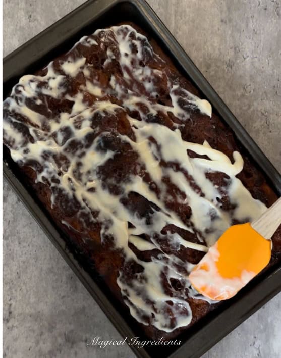 spreading the cream cheese icing on focaccia
